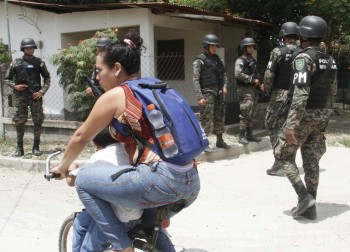 Photo from the article in La Prensa. Caption states; A young girl bicycles through Chamelecon, San Pedro Sula